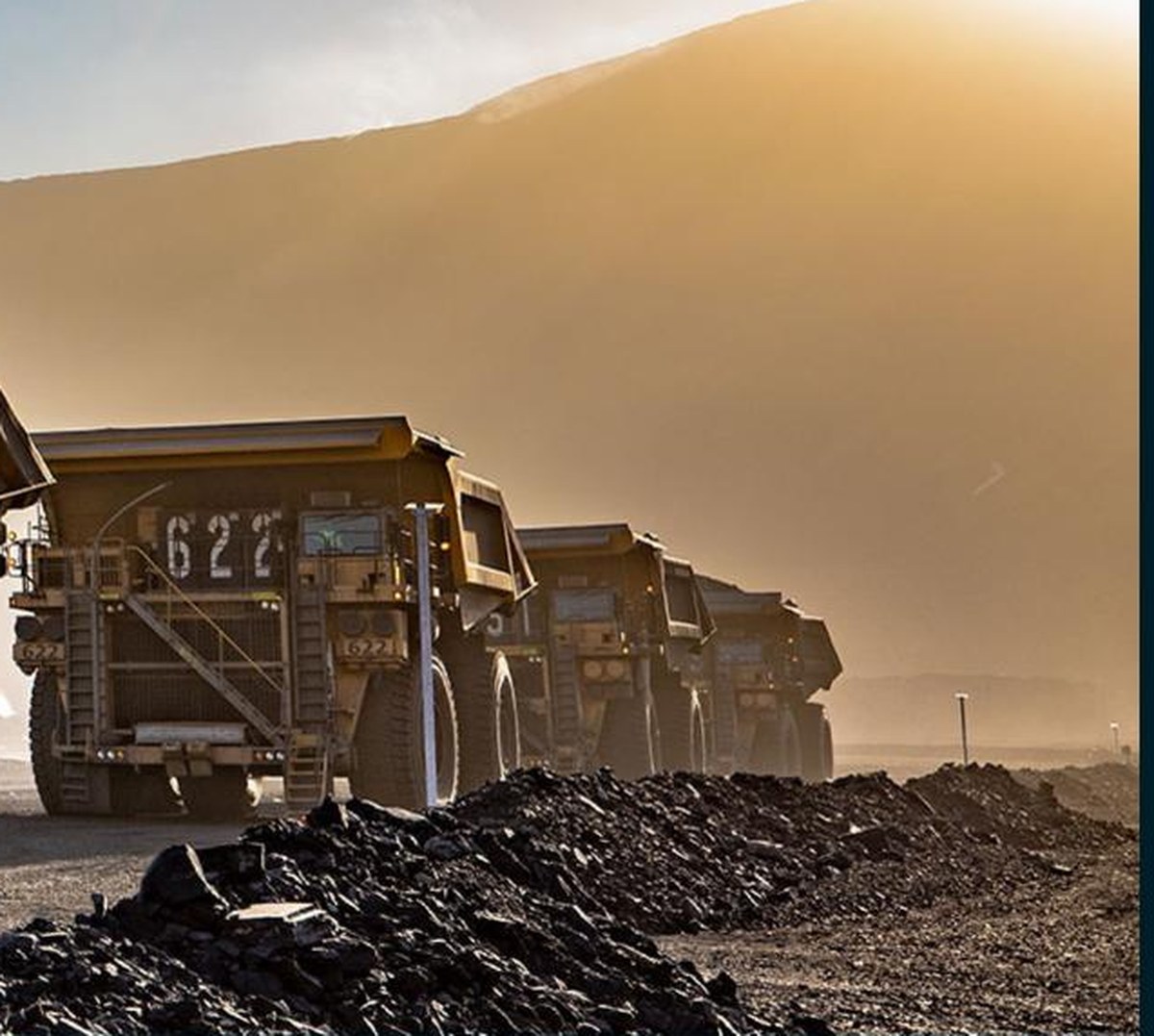Haul trucks operating on a dust-controlled mine road