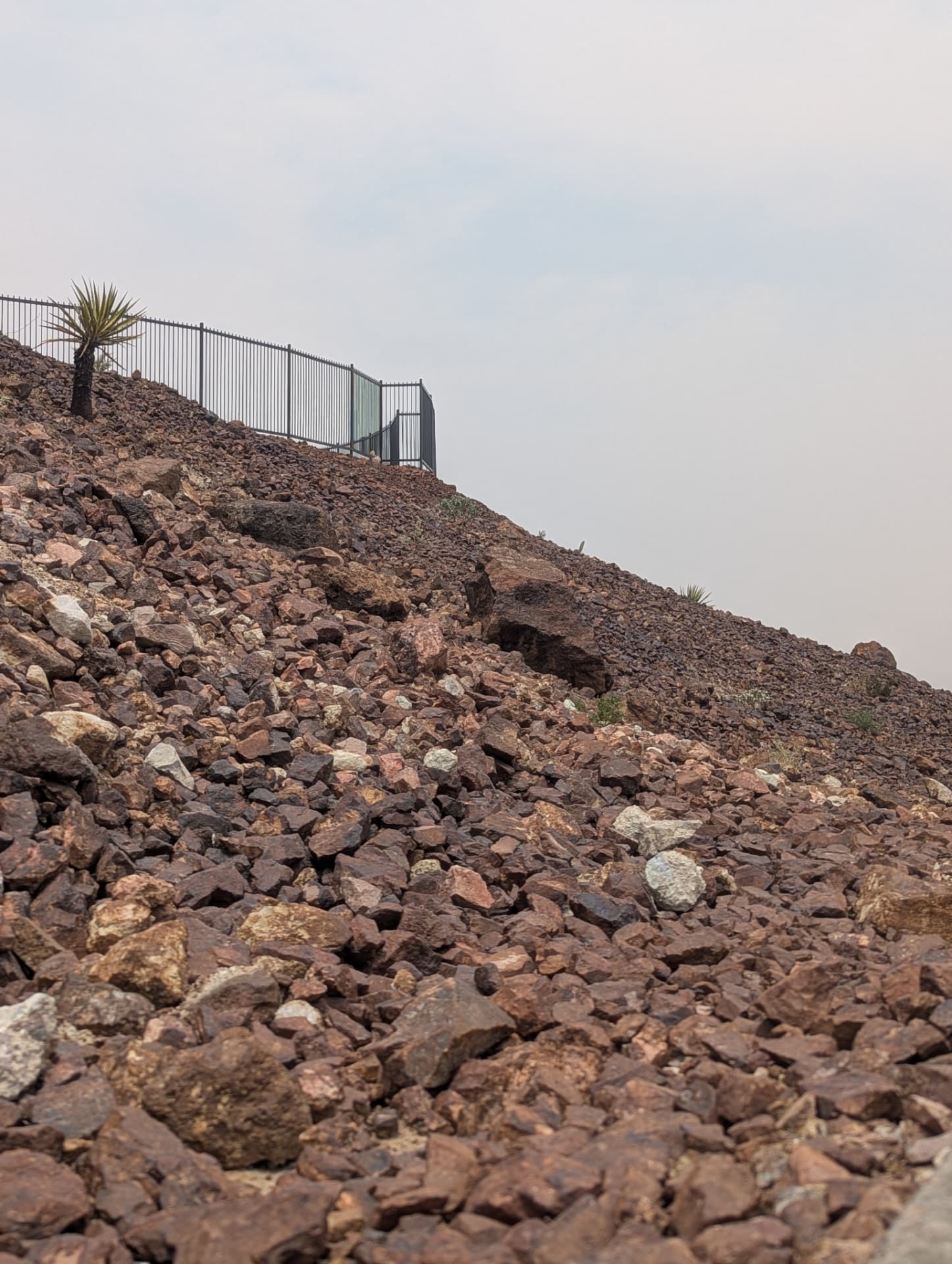 Rock slope treatment below perimeter fencing