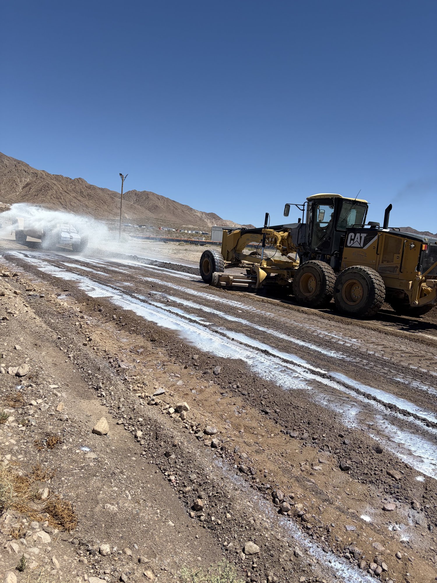 Grader and water truck conditioning a stabilized haul road